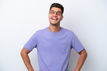 Young caucasian man isolated on white background posing with arms at hip and smiling