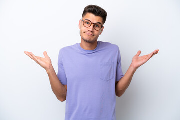 Fototapeta premium Young caucasian man isolated on white background having doubts while raising hands