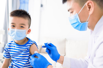 Medical Doctor injecting child with vaccine at clinic or hospital