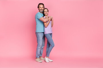 Full length photo of two peaceful cheerful people embrace toothy smile isolated on pink color background