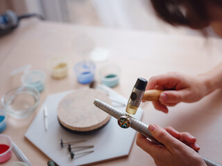 Lifestyle concept, work from home to reinvent your life - Jewelry designer workplace. Woman work with increase the ring size. Jeweler making accessories in workshop.