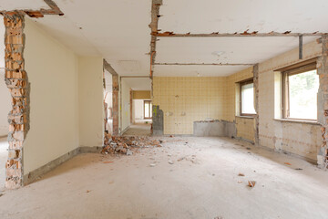 Large bright room with many windows of an old villa undergoing demolition and renovation. The walls have been knocked down and the floor is gone
