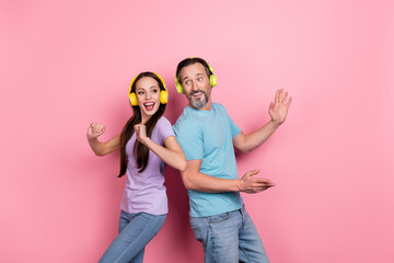 Photo of two excited crazy people enjoy listen favorite song dancing isolated on pink color...