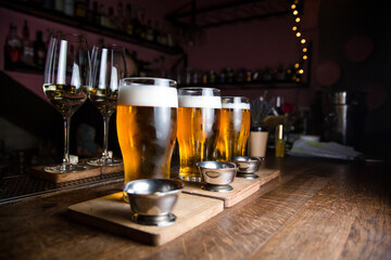Glasses with beer on a bar counter on a blurred bar background