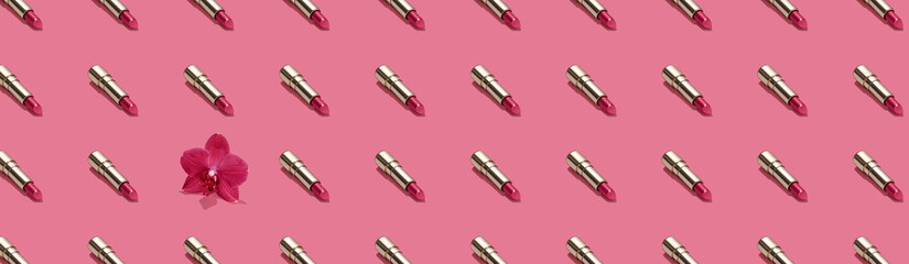 Creative seamless pattern of vivid pink golden lipsticks and orchid flower on bright pink background. Trendy and fashion makeup concept. Natural cosmetics backdrop. Web banner.