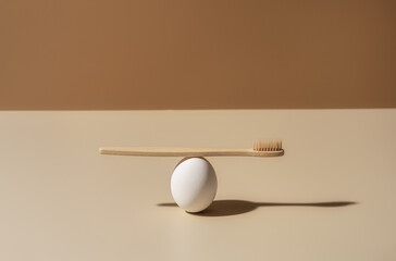 Organic wooden bamboo toothbrush and white egg composition on terracotta and beige background. Natural beauty and health concept. Eco-friendly zero waste design with copy space.