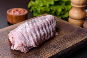 Fresh raw turkey wing with spices and herbs on a wooden cutting board