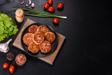 Fototapeta na wymiar Meatballs with tomato sauce and herbs on the black plate