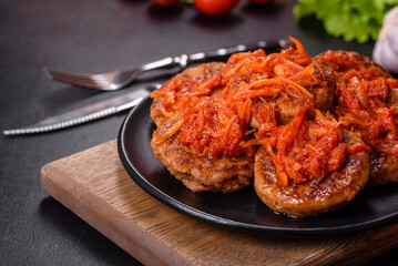 Meatballs with tomato sauce and herbs on the black plate