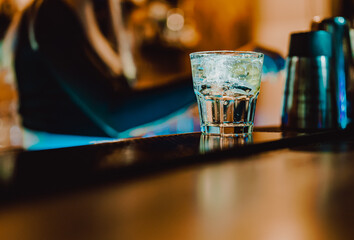 Woman bartender making cold gin tonic cocktail in bar
