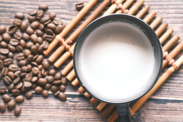 fresh coffee beans and cup of coffee on table 