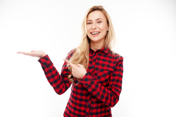 Obraz premium Attractive blonde girl promoter holding something in hand demonstrating empty space with excited face isolated on white background