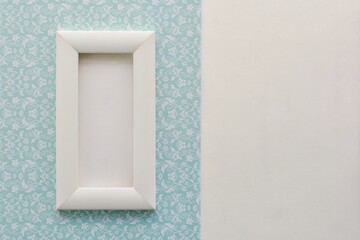 Mockup with white blank frame on gentle blue pattern paper  background 