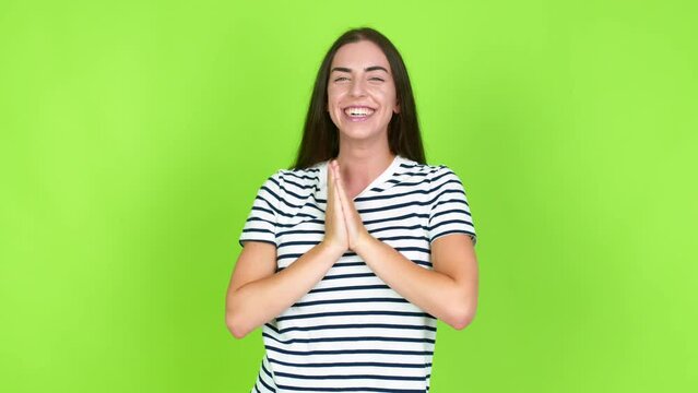 Young brunette woman smiling a lot while covering mouth over isolated background. Green screen chroma key