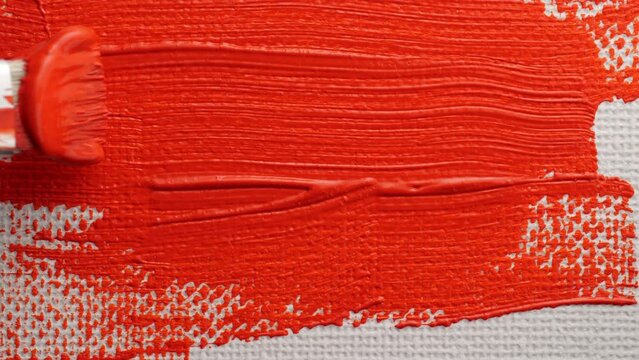 Red acrylic paint. Brush mix red color acrylic painting. Close up.