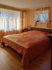 Small and cozy bedroom at the country house. Rural interior in the warm color palette. Retro...