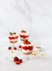 Berry dessert in glass with fresh strawberry, biscuit and whipped cream. Vegan lactose free dessert with alternative milk of coconut. Recipe of healthy organic dessert, cheesecake or berry trifle cake