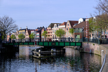 Haarlem, Netherlands - April 12. 2022: View over river Sparne towards old green swing bridge (Melkbrug) in springtime.