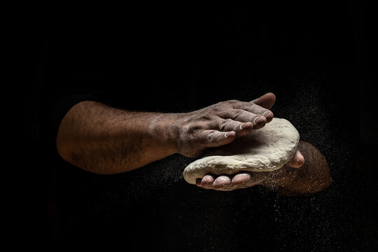 Clap hands of baker with flour. Beautiful and strong men's hands knead the dough make bread, pasta or pizza. Powdery flour flying into air. Long banner format