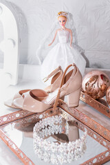 Bride's accessories, nude sandals and crystal tiara on a rectangular copper tray with a mirror in the background.