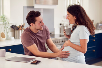 Obraz premium Excited Pregnant Transgender Couple At Home In Kitchen Together With Man Touching Woman's Stomach