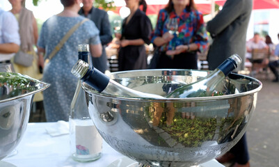 Cooler with bottles of wine and champagne in it at a social gathering