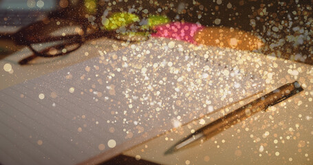 Image of white spots over notebook and pen