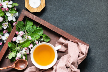 Organic herbal tea on the wooden tray with beautiful aromatic apple branches top view.