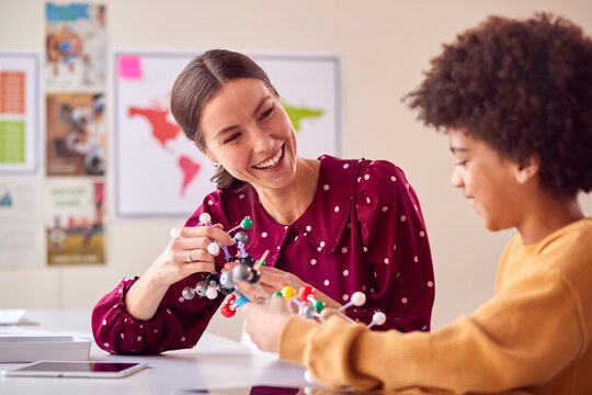 Teacher And Male Student In School Science Class Studying Molecular Model - Powered by Adobe