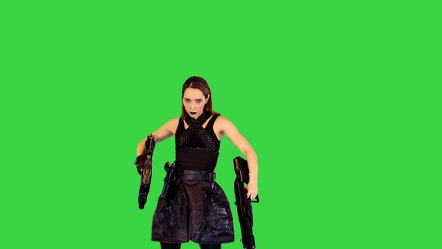 Cyberpunk girl in black military clothes poses with machine guns and goes away on a Green Screen, Chroma Key.