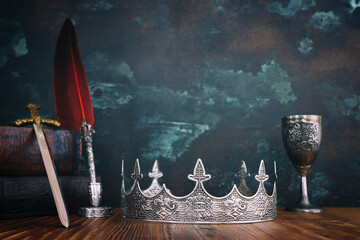 low key image of beautiful queen or king crown next to sword. fantasy medieval period. Selective...