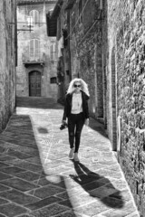 Young woman walking on a narrow lane In The Center Of San Gimignano, Tuscany, Italy, Europe