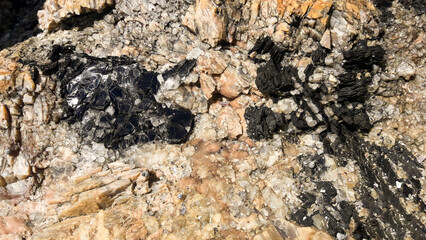 Pequenas pedras pretas na beira da praia, localizado em um município do estado do Espírito Santo, Brasil.