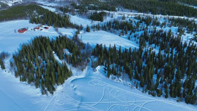 Scenic aerial video of forest in Norwegian snowy mountains. A lot of snowmobile traces. Hattfjelldal municipality in Nordland county, Norway