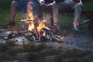 Freunde sitzen am Lagerfeuer beim Campen