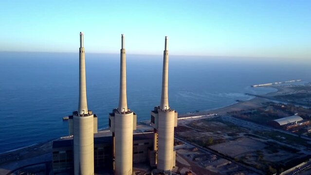 iconic aerial drone image of Badalona three towers next to Barcelona at  sunset with amazing skies the beach and sea at the background  the buildings in foreground