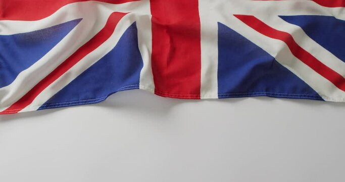 Video of creased flag of great britain lying on white background