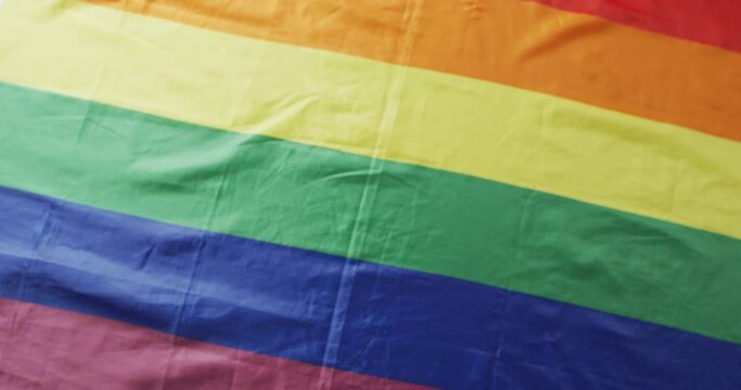 Video of rainbow flag lying on white background