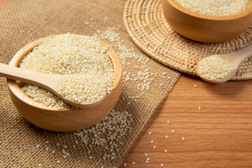 White sesame seeds in wooden spoon and bowl,close up and choose a focus point.