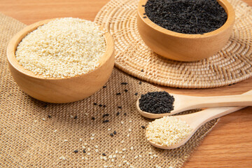 White and black sesame in wooden spoon and bowl,close up and choose a focus point.