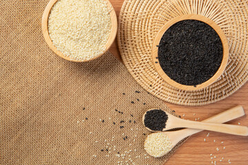 White and black sesame in wooden spoon and bowl,close up and choose a focus point.