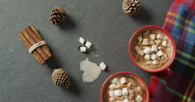Video of coffee with marshmallows, pine cones and cinnamon on grey background