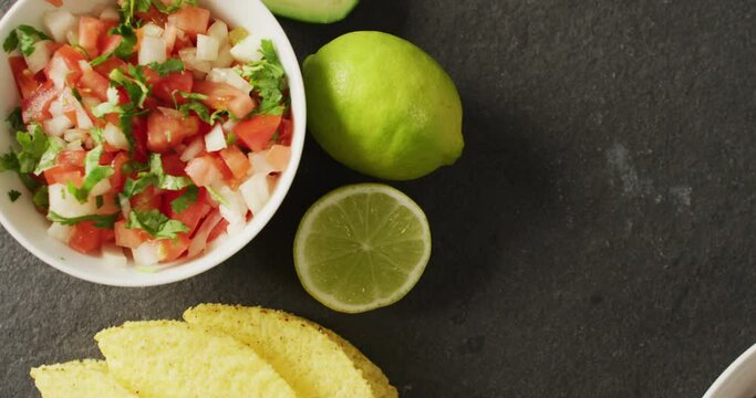 Video of tacos, salad, meat lemon and other ingredients lying on black background