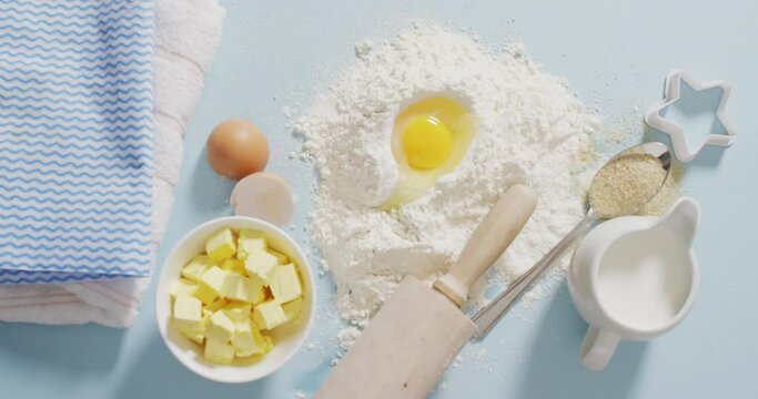 Video of baking ingredients, muffin papers, eggs and tools lying on white surface
