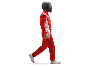 Full length profile shot of a racer in a red suit and black helmet walking