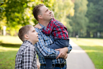 Little boy in the father's arms. head on dad's shoulder. Parental relationship. Hugging your child.