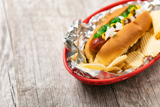 Delicious Hot Dog And Chips On Wood Background