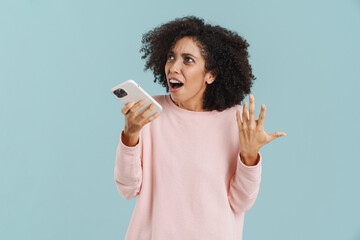 Young hispanic woman smiling while talking on mobile phone