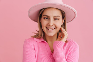 Young beautiful lady in pink hat touching her cheek