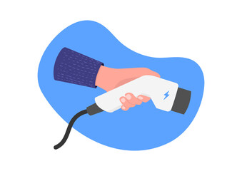 Hand hold electro plug connector on blue background. EV charging plug in hand. Electric car concept.